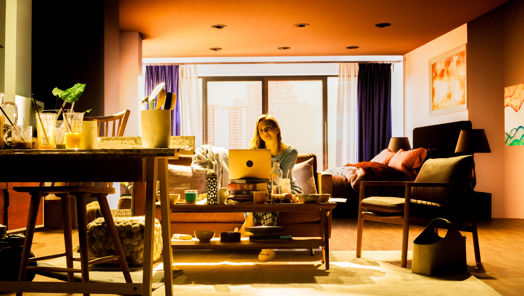 Actor in a virtual production set with a screen in the background showing the inside of a room