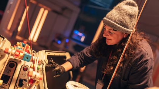 Woman wearing gloves painting part of the set on the set of Doctor Who