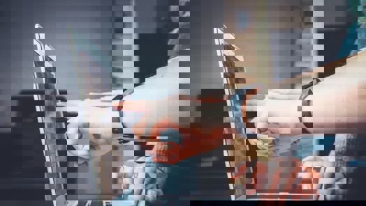 Close-up of hand pointing to laptop screen