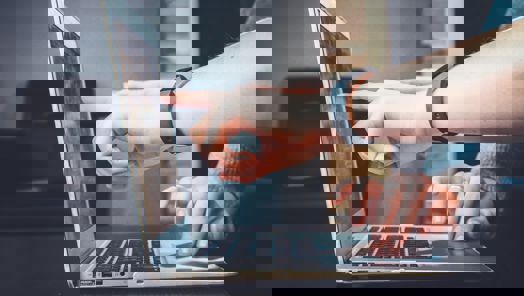 Hand pointing to laptop screen