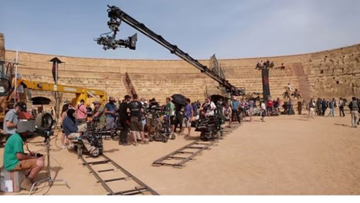 A busy film set with a large crane in the centre