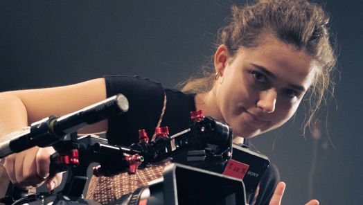 Young woman holding a camera gives a 'V' sign