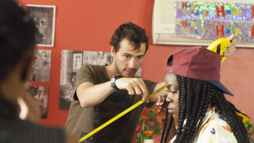 Young man holding measuring tape next to seated young woman
