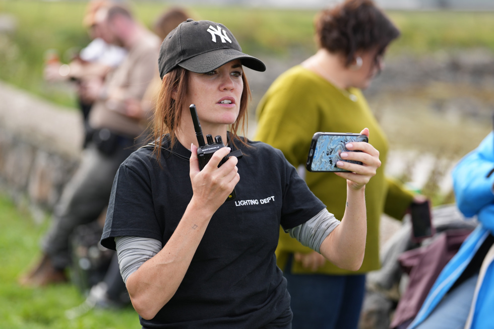 First AD Sheena Kelly holds a walkie talkie in her hand on the production of Ellis