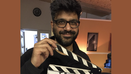 Irshad Ashraf holding a clapper board