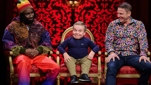 Taskmaster's Lenny Rush sits on a chair with two guests either side